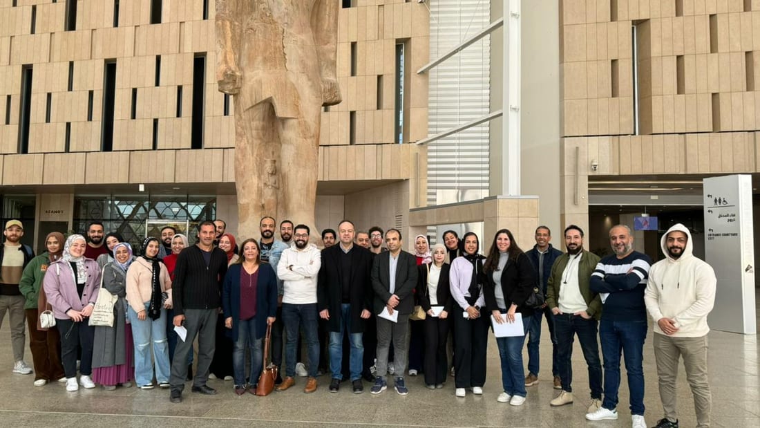 A cohort of practitioners standing together in the atrium of a training venue